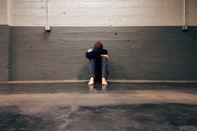 depressed person sitting in a garage