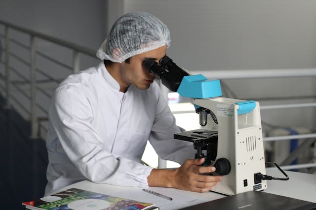 researcher looking through microscope