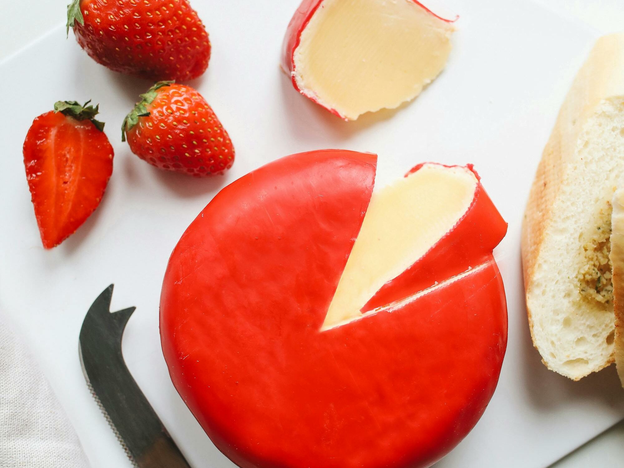 wheel of gouda cheese with red wax