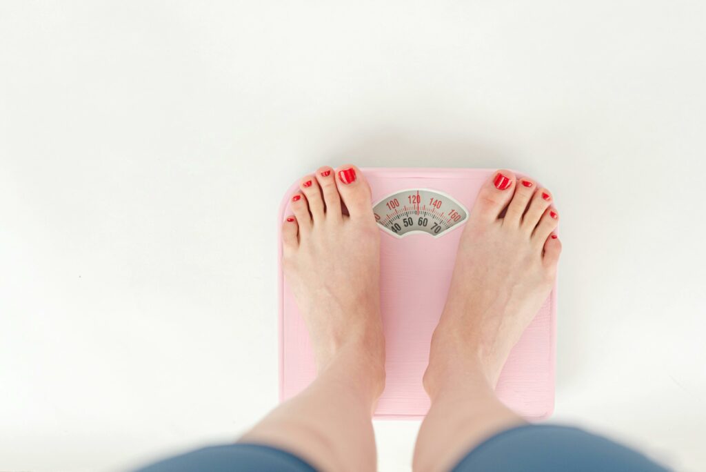 Woman weighing on scales in studio