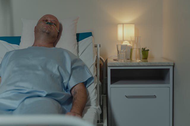 man lying in hospita; bed
