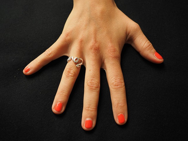 a hand with red-painted fingernails