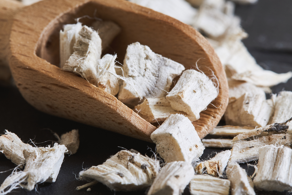 Dried and sliced marshmallow root (Althaea officinalis) in wooden scoop