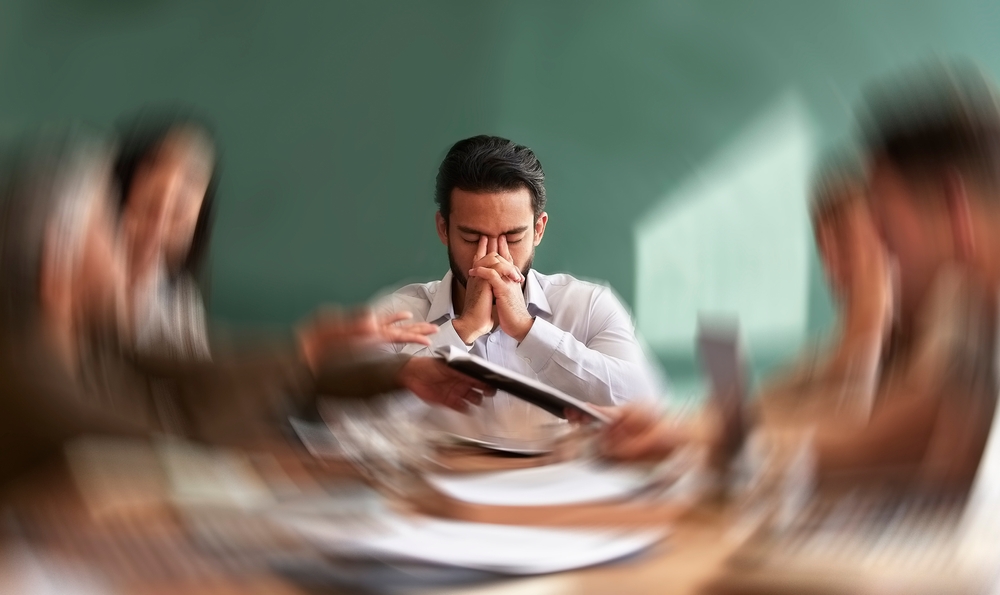 Stress, migraine and motion blur with a business man in a meeting feeling frustrated, tired or overworked. Mental health, anxiety and headache with an exhausted male employee suffering from fatigue
