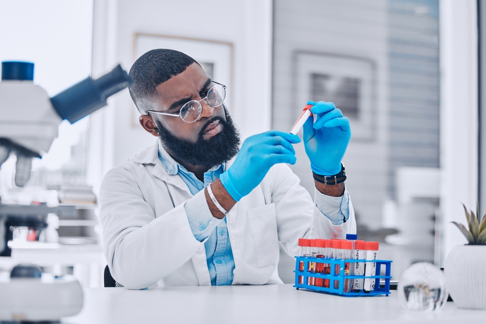 Sample analysis, research and a scientist with blood for science or pharmaceutical healthcare in a lab. Focus, doctor or a black man with a dna vial for virus test, technician work or expert check