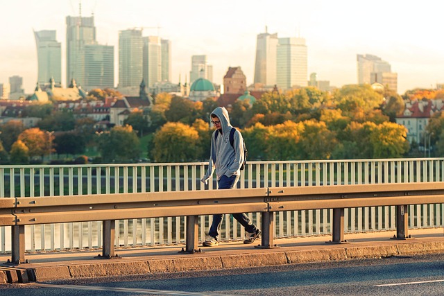 man walking through cityscape lined with trees