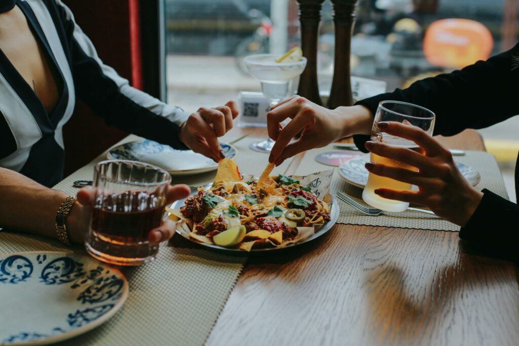 Close-up of Friends Sharing Food at Restaurant Table