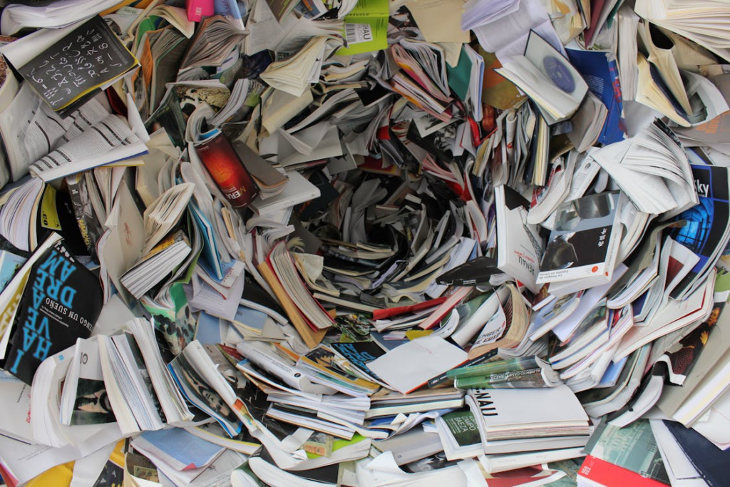 A chaotic stack of books sits in a hole, symbolizing a cognitive style that values ideas more than appearances.