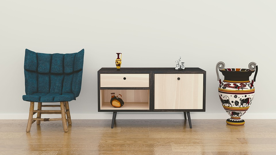 A cozy wooden floor with a single-seater couch, a decorative table, and a pot, resembling a showroom. 