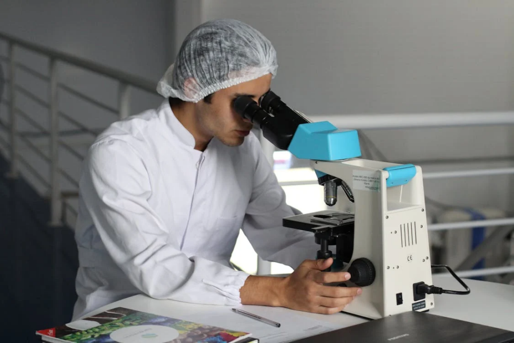A researcher in a white lab coat peers into a microscope, analyzing reverse aging with increased collagen production.