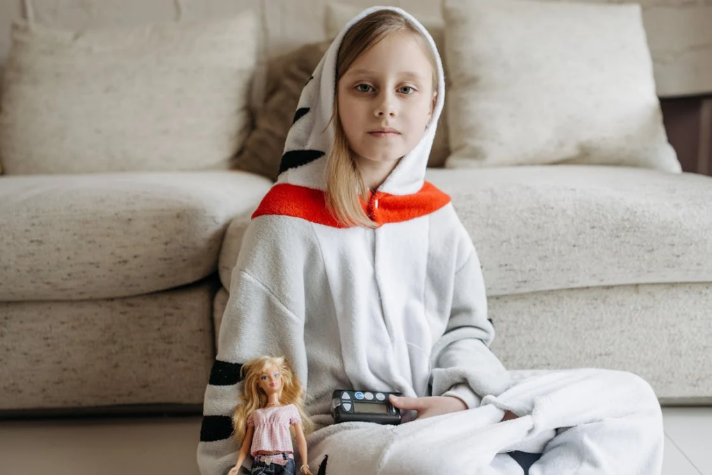 Girl Wearing a Onesie Holding an Insulin Pump