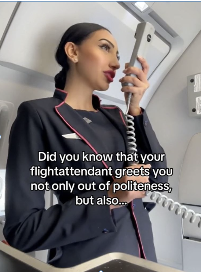 Female cabin crew member standing in front of the exit of an airplane making an announcement.