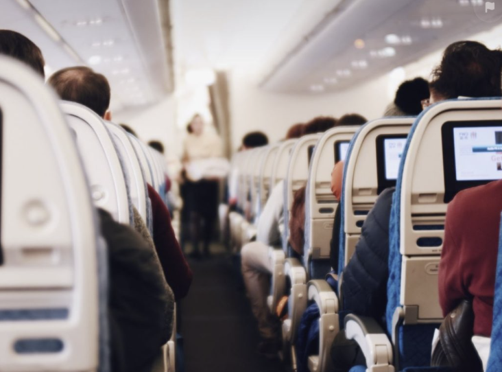 Rows of passengers inside an airplane.