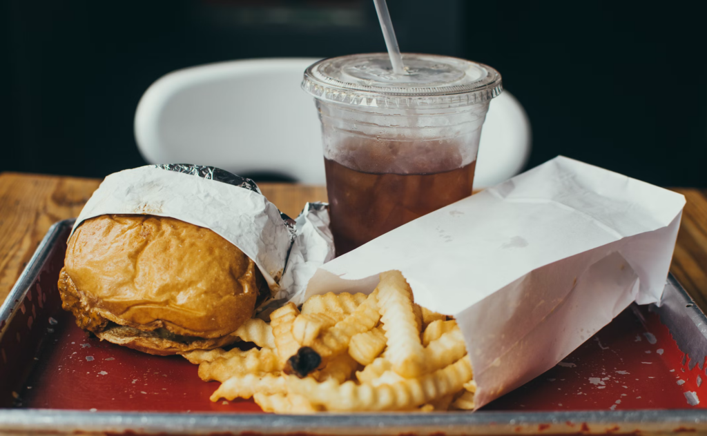 A tray featuring a burger and fries, highlighting potential inflammatory foods that may affect arthritis symptoms. 