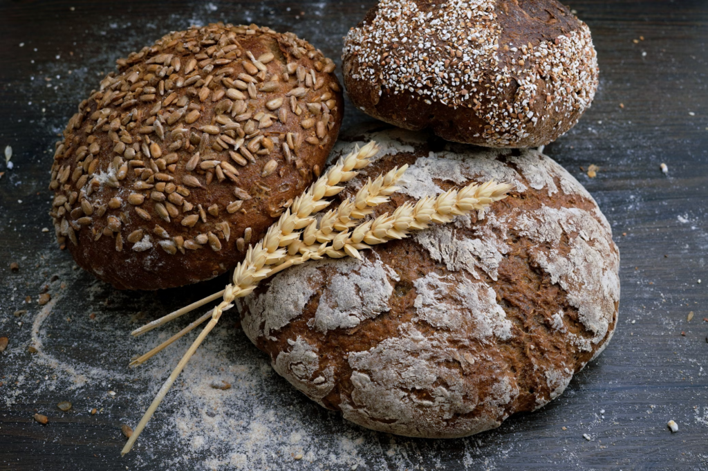 Three varieties of bread arranged on a table, showcasing choices mindful of gluten sensitivity and inflammation concerns.