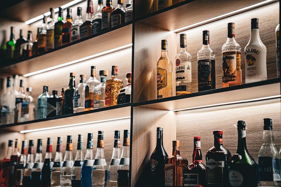 A wall shelf displaying various alcohol bottles, highlighting the need for seniors to reconsider their consumption habits.