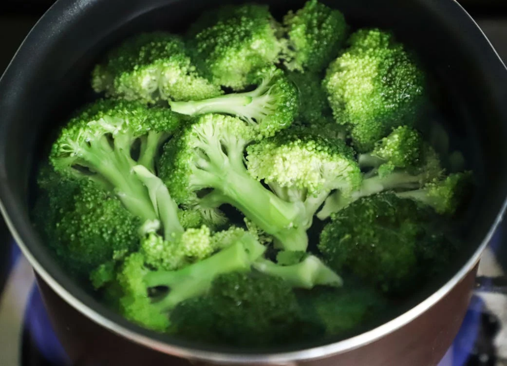 A pot of broccoli cooking on the stove, showcasing the importance of healthy eating 