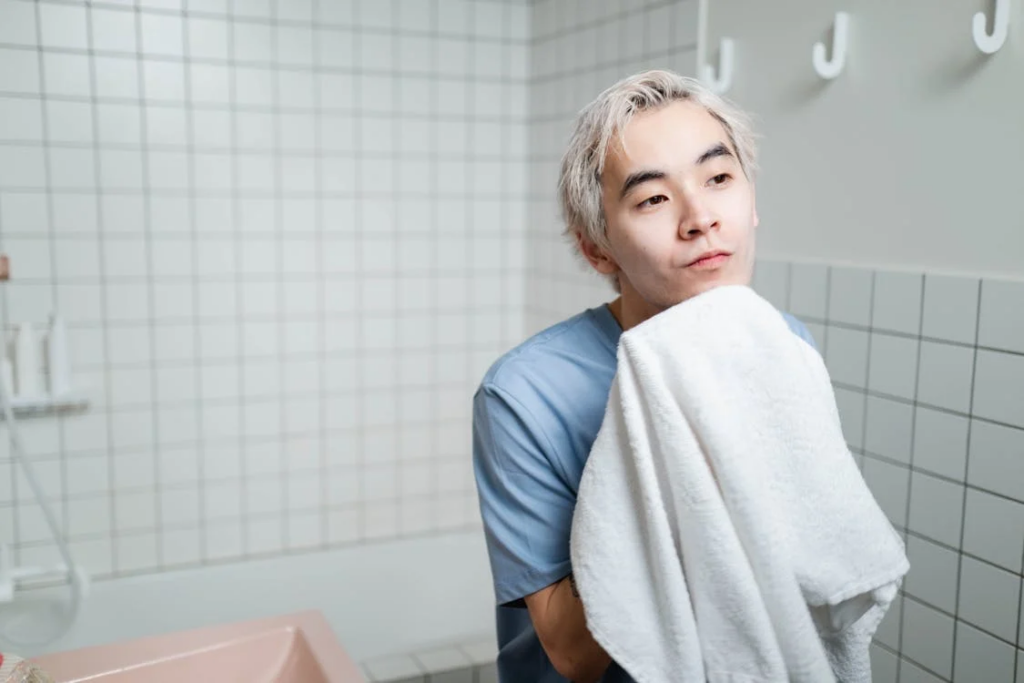 Man in Blue Shirt Holding White Towel
