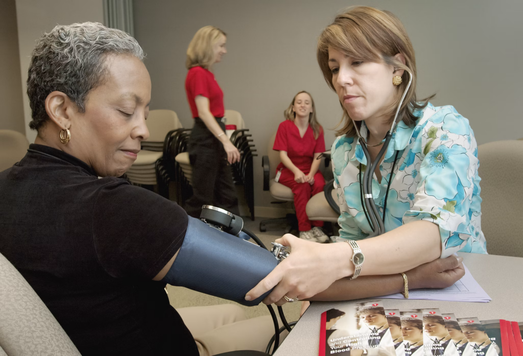 A healthcare professional checking the blood pressure of a patient using a sphygmomanometer. This scene highlights the importance of monitoring and managing hypertension, which is closely linked to sleep apnea.