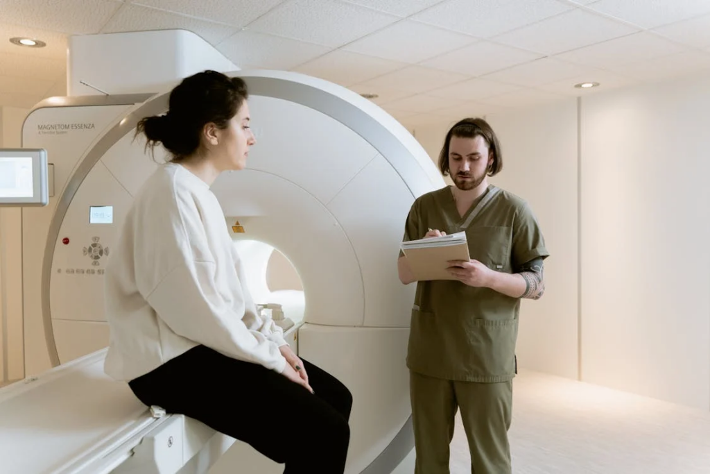 A healthcare professional discusses the patient's information near an MRI machine. This interaction may be part of diagnosing early Parkinson's disease symptoms, as MRIs can reveal brain changes linked to the condition.