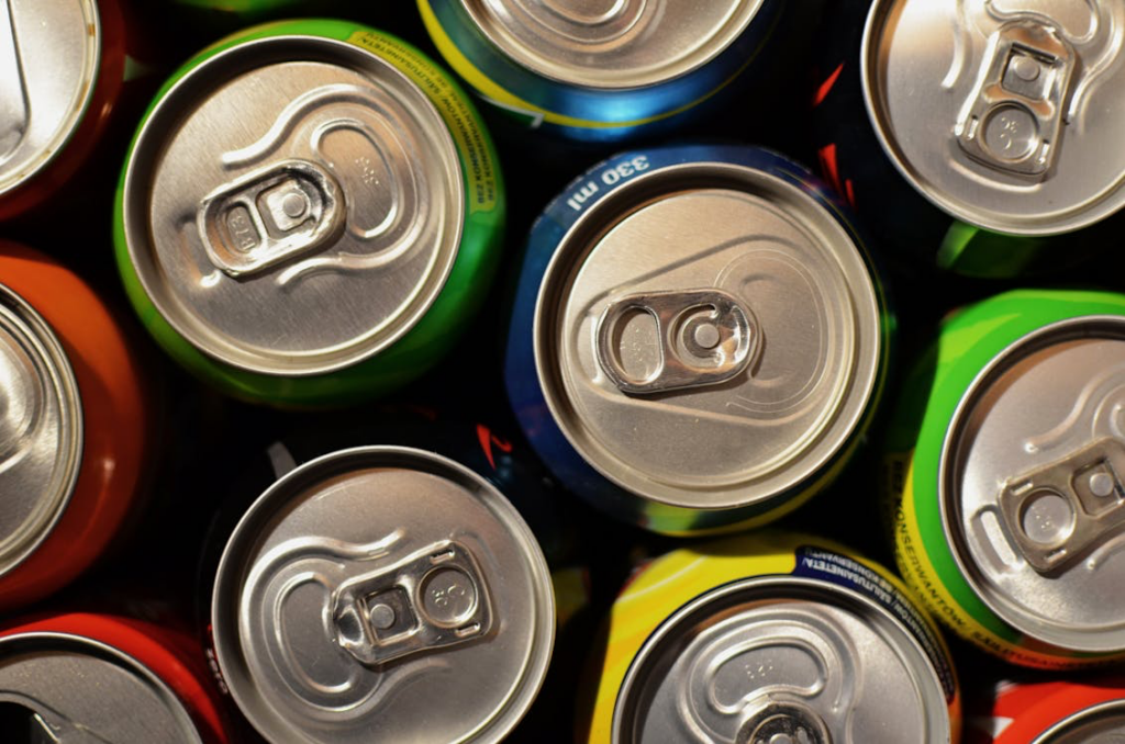 The image shows a collection of soda cans, highlighting the widespread availability and consumption of these beverages.