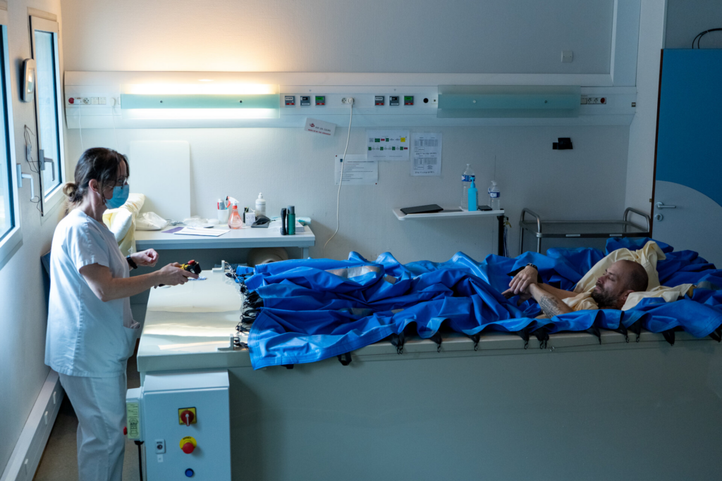 A nurse attends to a volunteer who is lying in a special bed to participate in The Space Agency volunteer offer study.