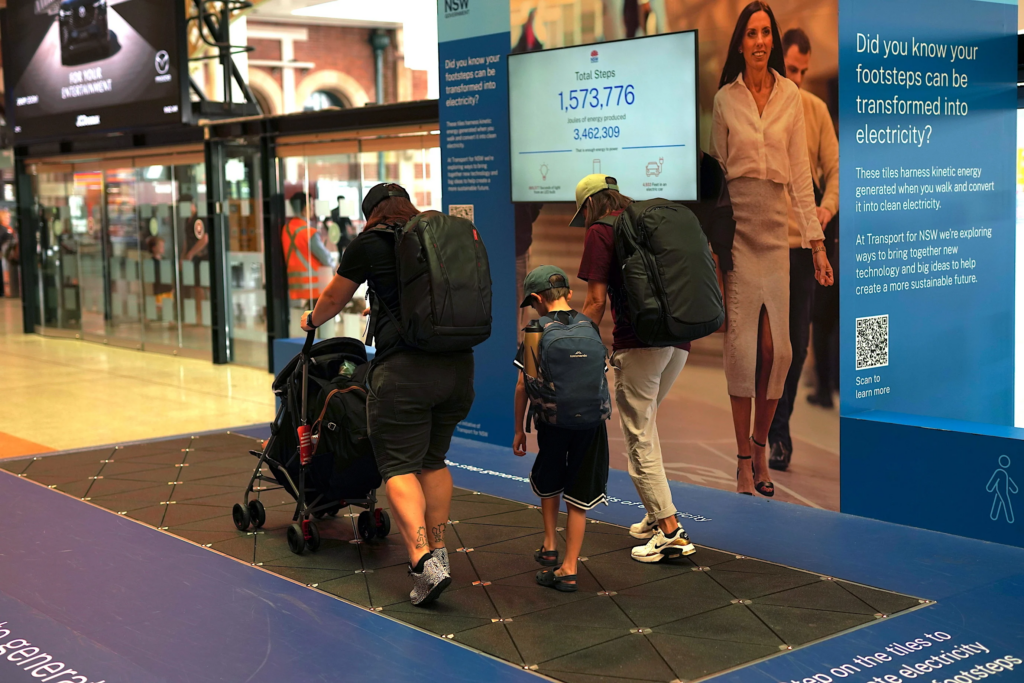 family walking over a Pavegen energy-harvesting tile installation 