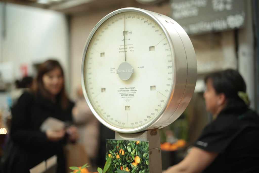 Large industrial weighing scale with blurred background of people.
