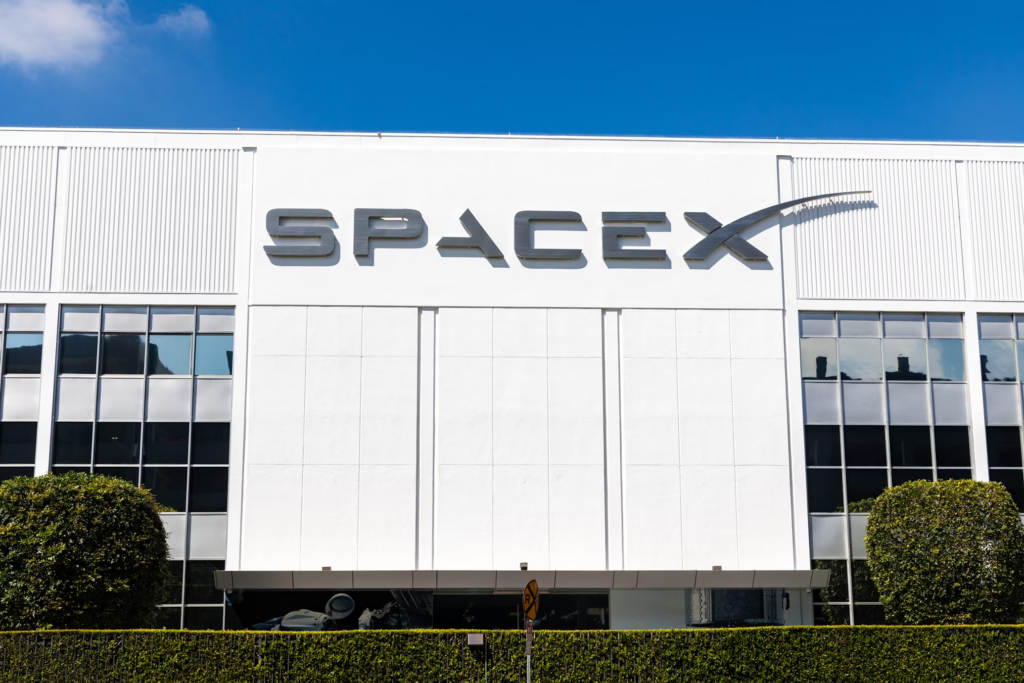 SpaceX headquarters building with company logo displayed on white exterior wall under blue sky. The facility where innovative job interview questions are asked.