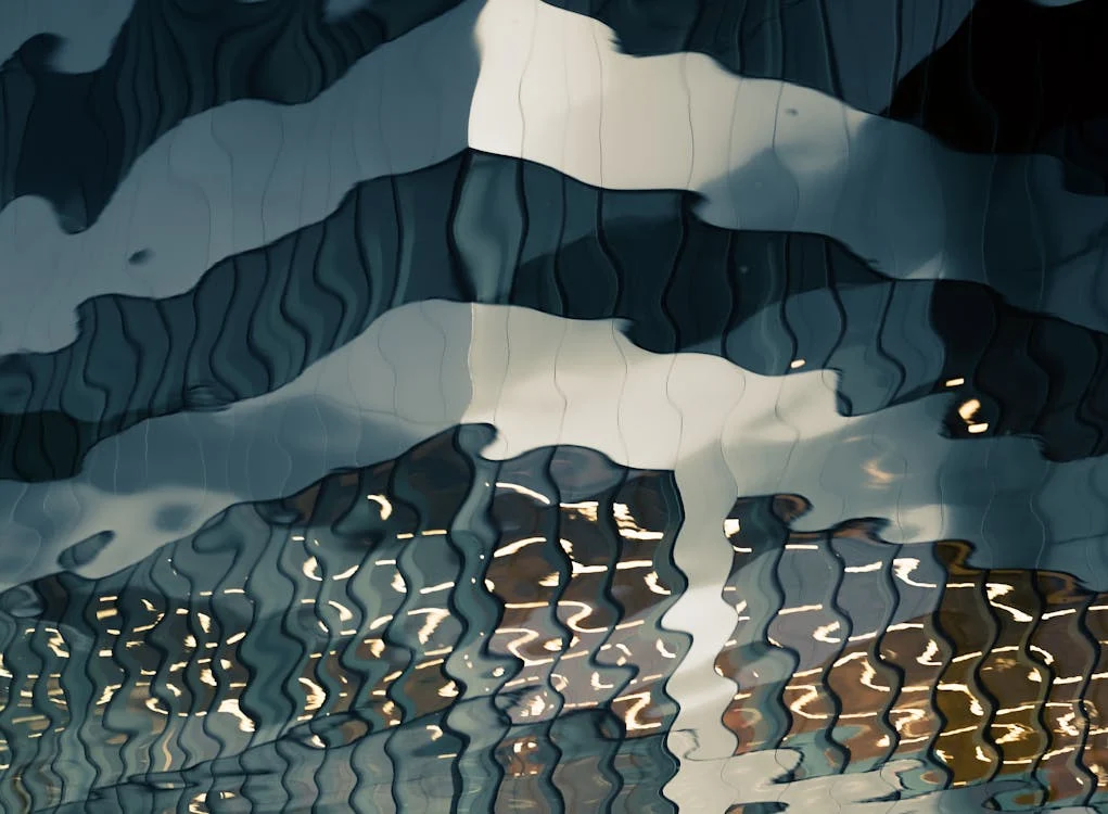 Rippling water surface creating abstract wave patterns with light reflections.