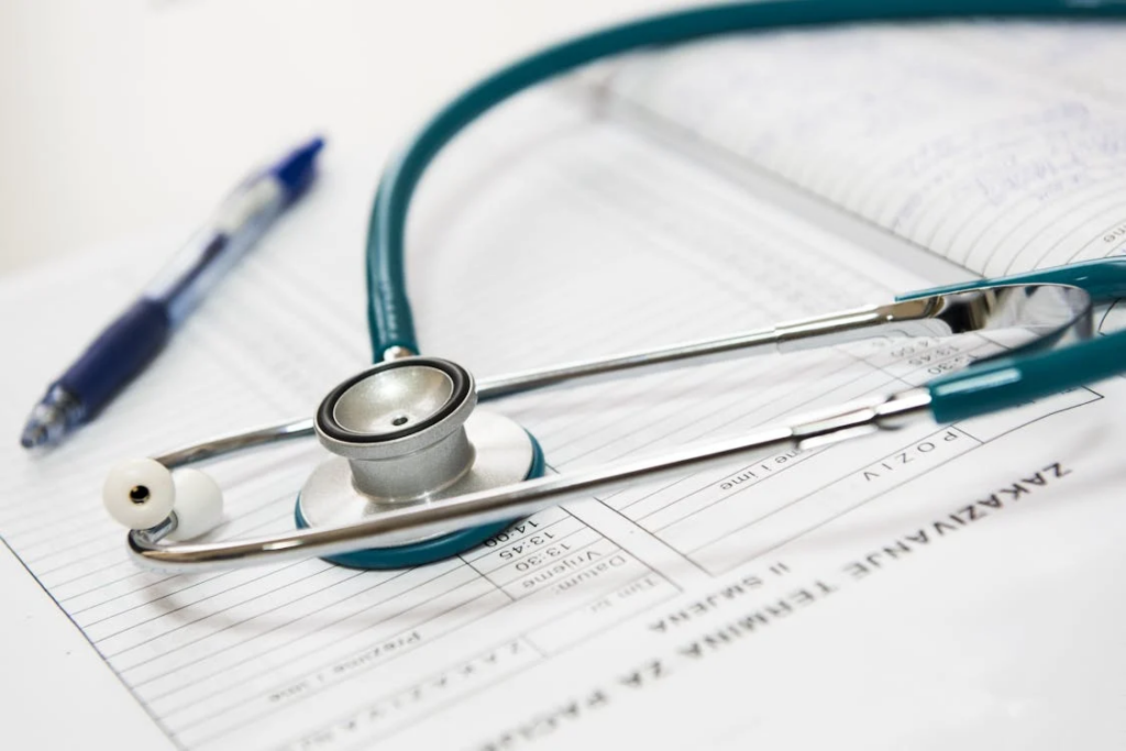 Stethoscope resting on medical charts and patient forms.