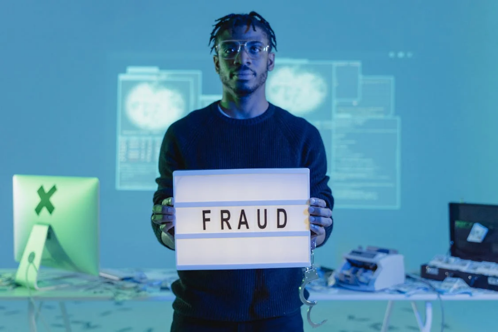 Person holding illuminated 'FRAUD' sign against tech background, depicting how Meyer's water-powered car was proven scientifically fraudulent.
