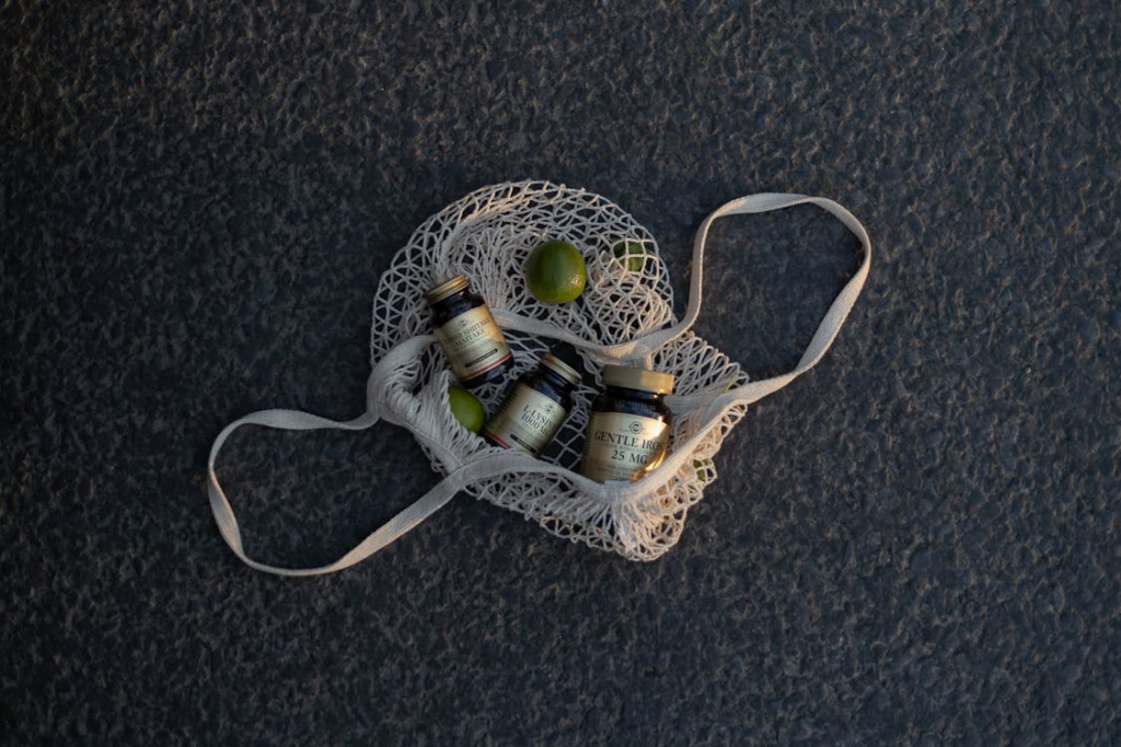 Bottles of Supplements and Limes on a Mesh Bag