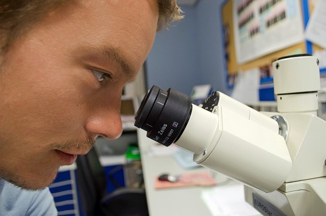 researcher looking through microscope