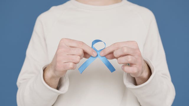 hands holding blue prostate cancer awareness ribbon