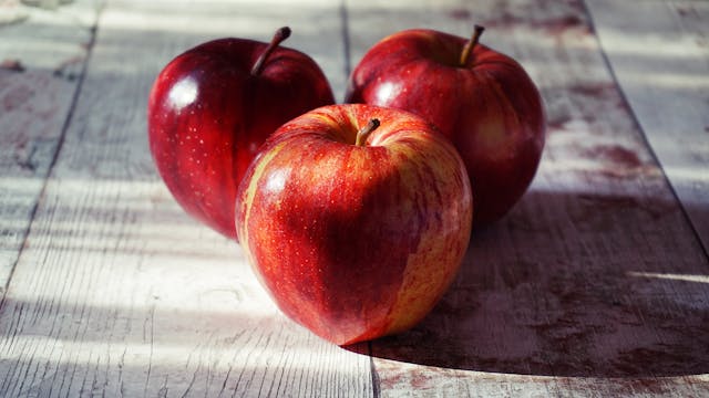 three apples on a table