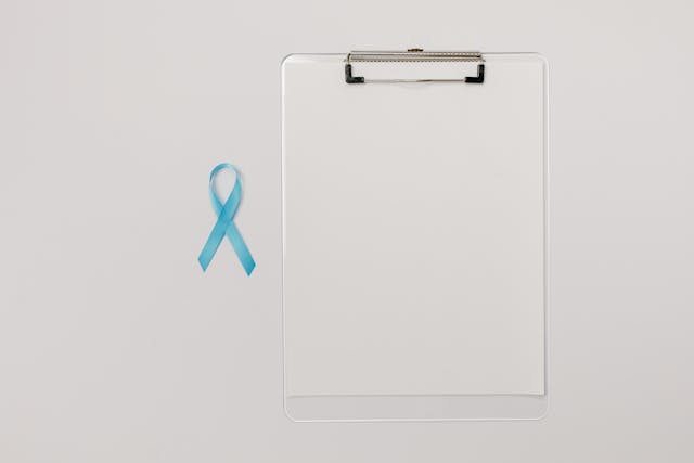 blue prostate cancer awareness riboon next to clip board