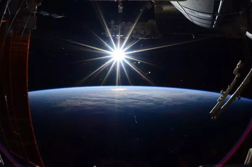 An image of the top of the planet from space. Space and a bright star in the background. 