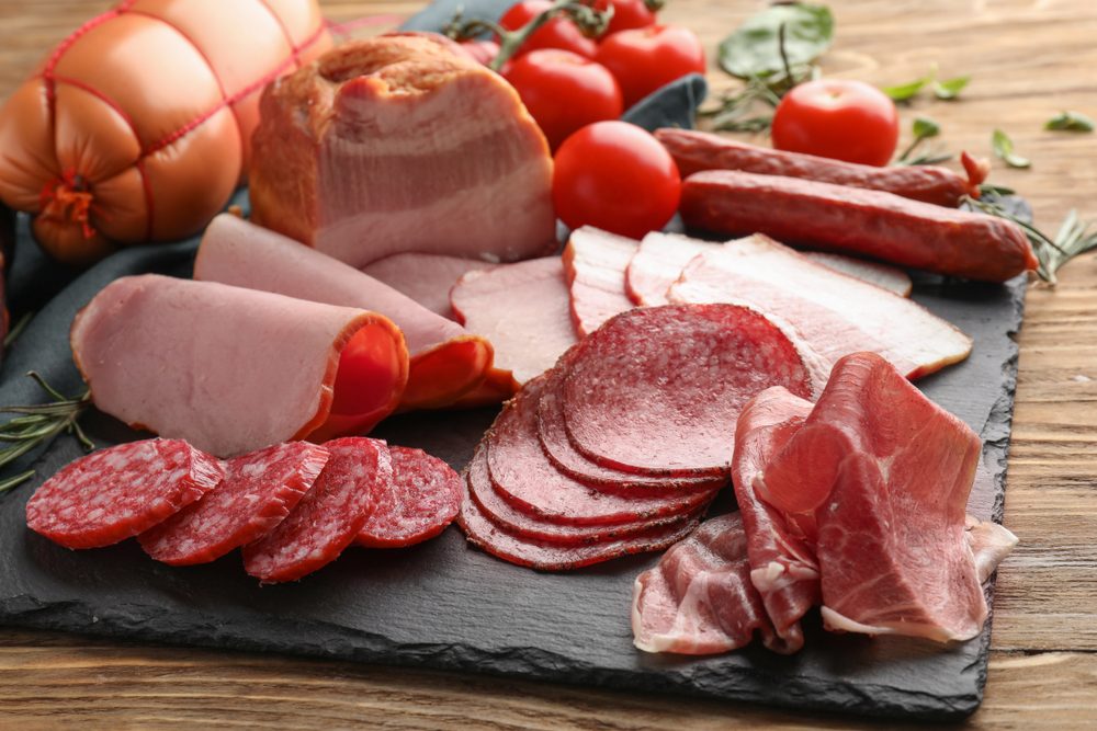 Assortment of delicious deli meats on slate plate

