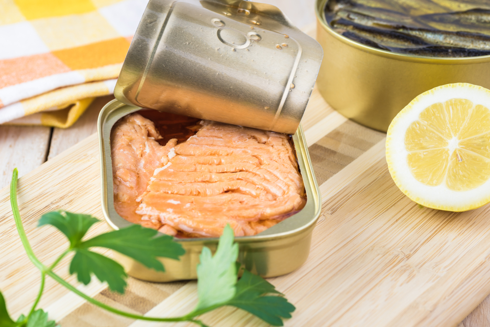 Open canned fish. Tin can with smoked salmon fillets.