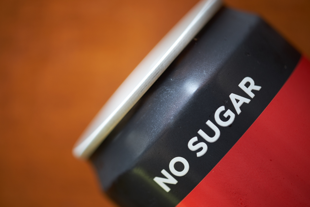 Close up of sugar free drinking cans. Metal container of carbonated soft drink, alcoholic, fruit juices, teas, and energy drinks. Tin can on wooden backgroud.