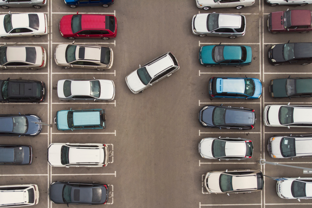 Regularity in car parking. A view to carefully parked ranks of cars. Car navigation in the car park. Searching for vacant space for parking. The parking is jammed with cars. Parking problem