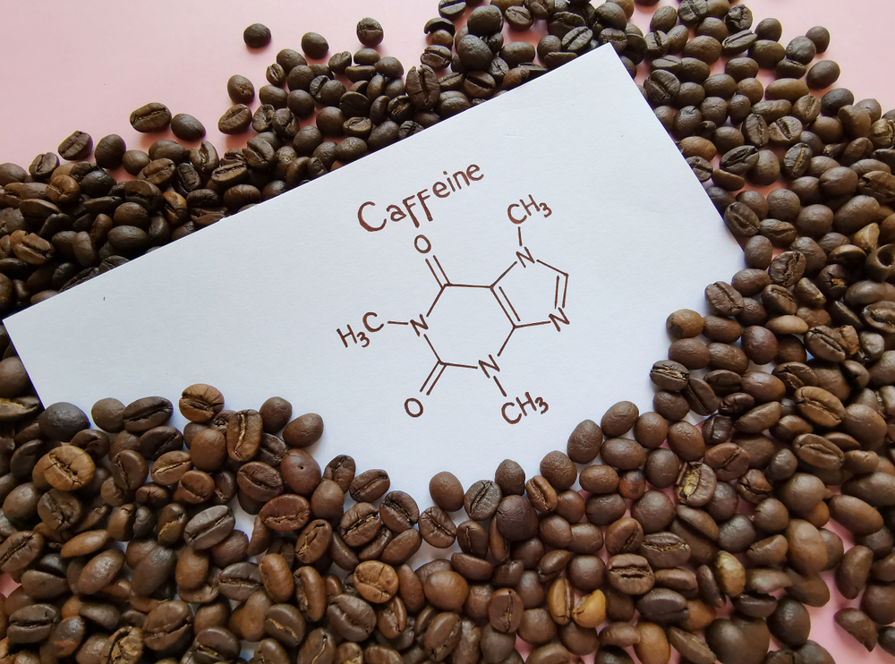 Structural chemical formula of caffeine molecule with roasted coffee beans. Caffeine is a central nervous system stimulant, psychoactive drug molecule.