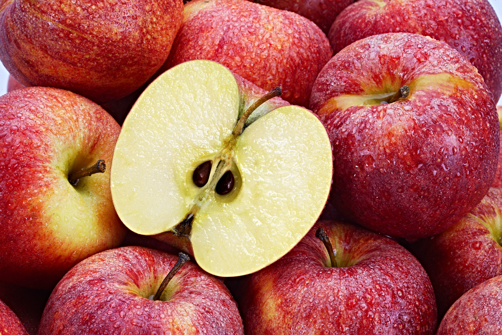 Several Red Apples with cut apple in the foreground
