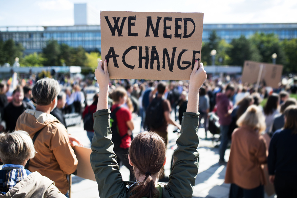 Rear view of people with placards and posters on global strike for climate change.
