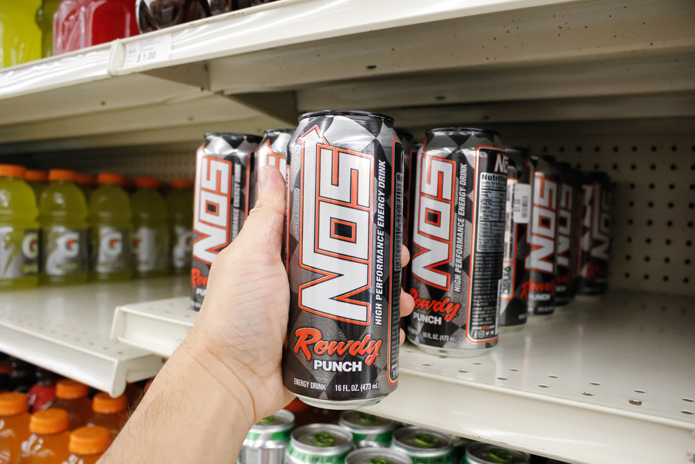 Long Beach, California, United States - 02-12-2020: A hand holds a tall can of Nos energy drink on display at a local grocery store.