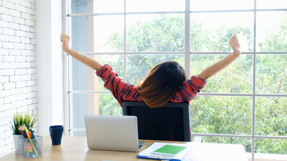 Work from home, Stretch for relax, Young asian woman stretching body while working with laptop computer at her desk home office, Back of female student raised arms take rest from online education
