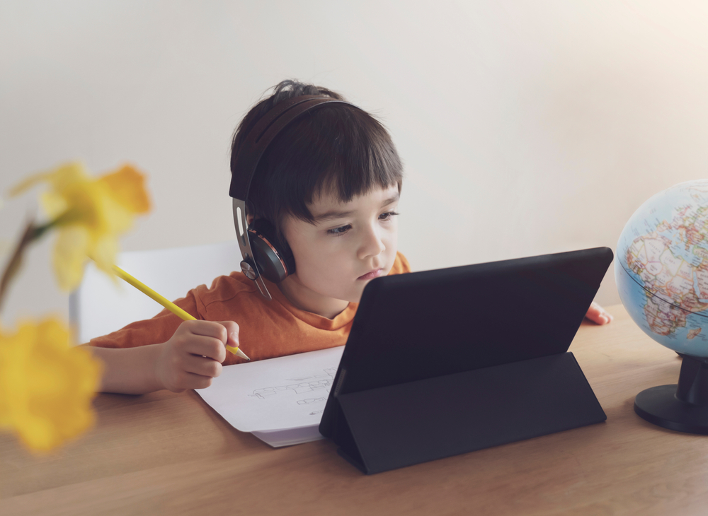 Kid Online Education,Asian Child using tablet technology for homework,Schoolboy wearing headphones listen and reading information from internet, Kindergarten learning world environment,Back to school
