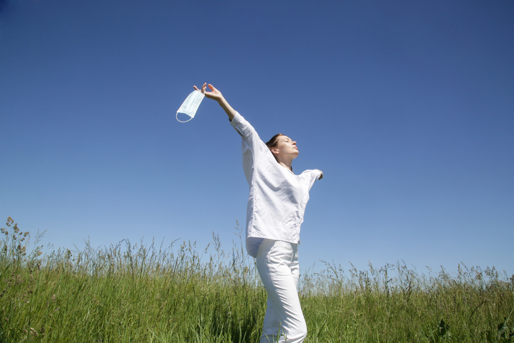 Coronavirus is finish. The end of quarantine and Corona Virus pandemic. Woman taking off and throw away medical protective mask. Enjoying life and fresh air after coronavirus pandemic. 
