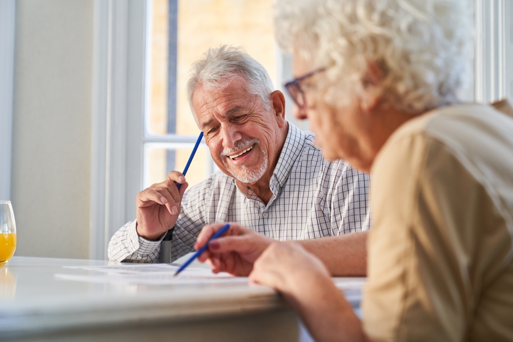 Couple of seniors has fun solving puzzles as a memory training against Alzheimer's and dementia